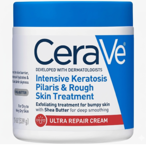 CeraVe white jar with blue lid and label for Intensive Keratosis Pilaris and Rough Skin Treatment. The label shows 19 oz size and features a red banner with skin icon for Ultra Repair Cream with Shea Butter.